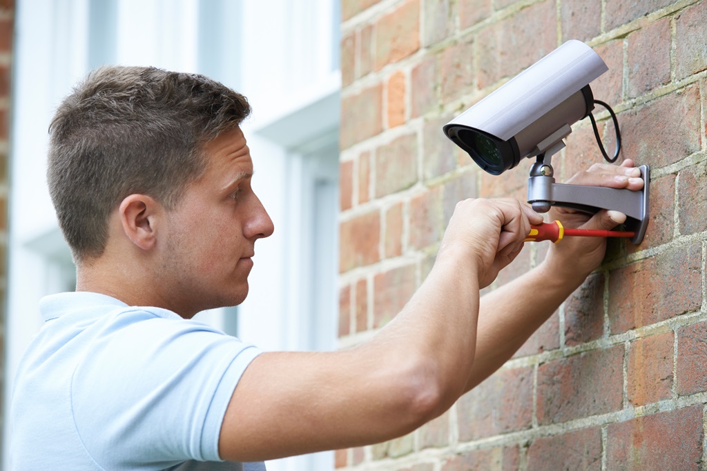 Security Consultant Fitting Security Camera To House Wall cctv and wireless alarms leeds